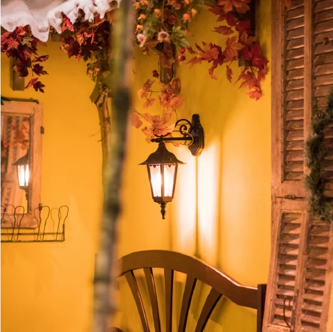 Hoofdingang van het restaurant, gele muur, authentieke kozijnen en dakpannetjes.